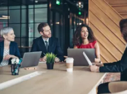 Learn How Vanguard Seeks to Cut the Cost of Index Tracking Error People around a table