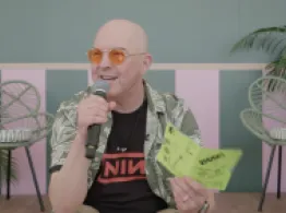 Dave Nadig’s 16 Pages of Zine, 15 Minutes of Truth Dave Nadig smiles while talking and holding a neon yellow covered quarter-page sized zine.